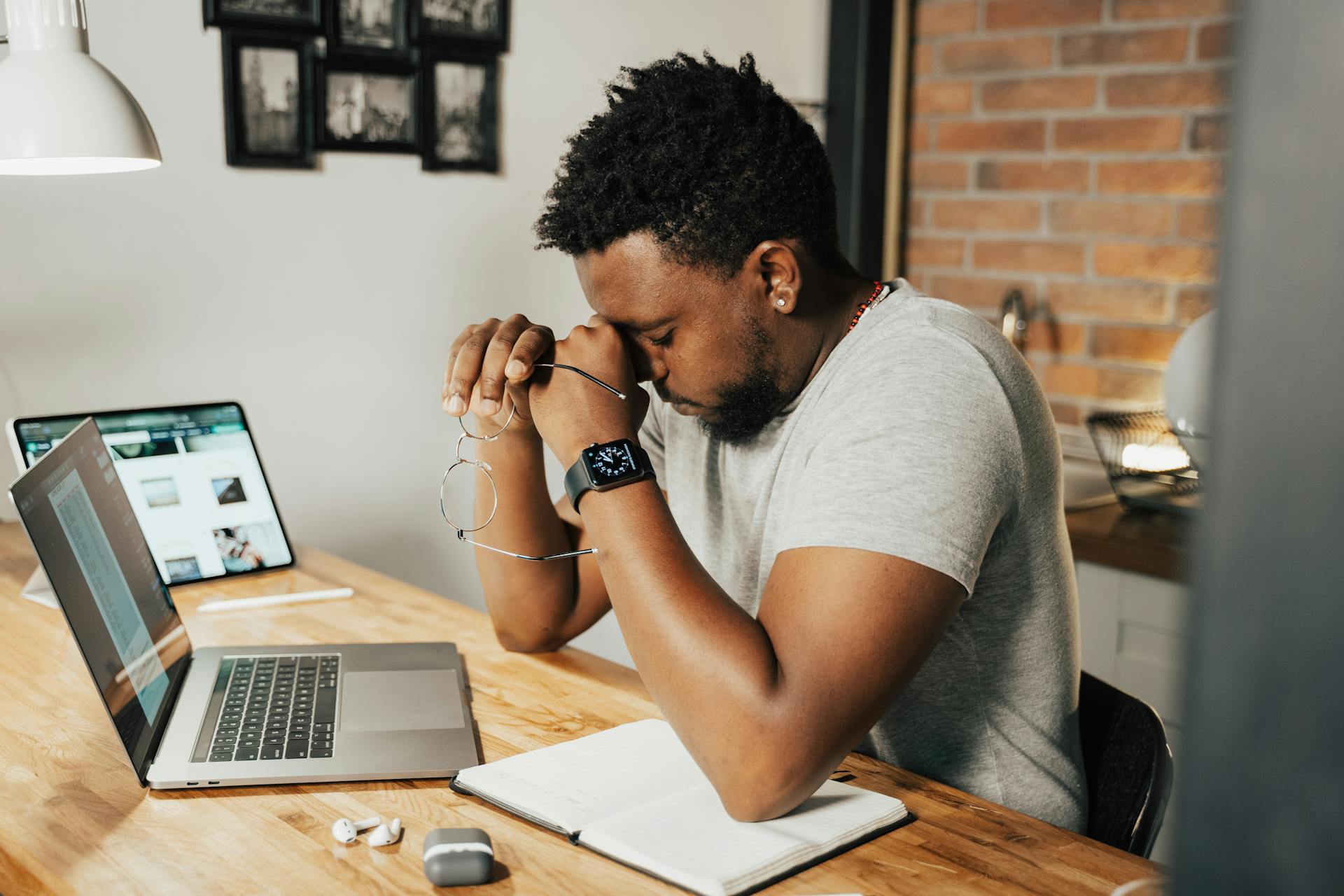 Exhausted developer rubbing his eyes at a desk with a laptop